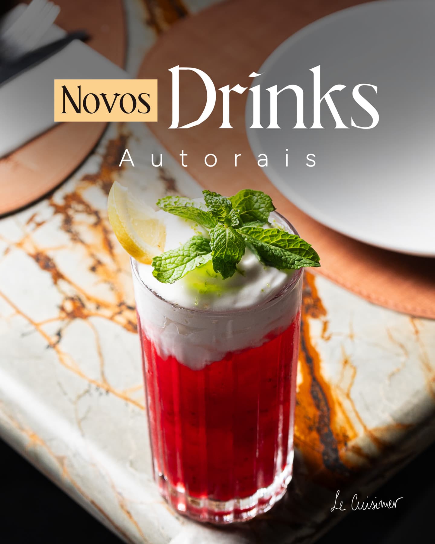 Drink autoral vermelho com espuma, hortelã e limão sobre mesa de mármore